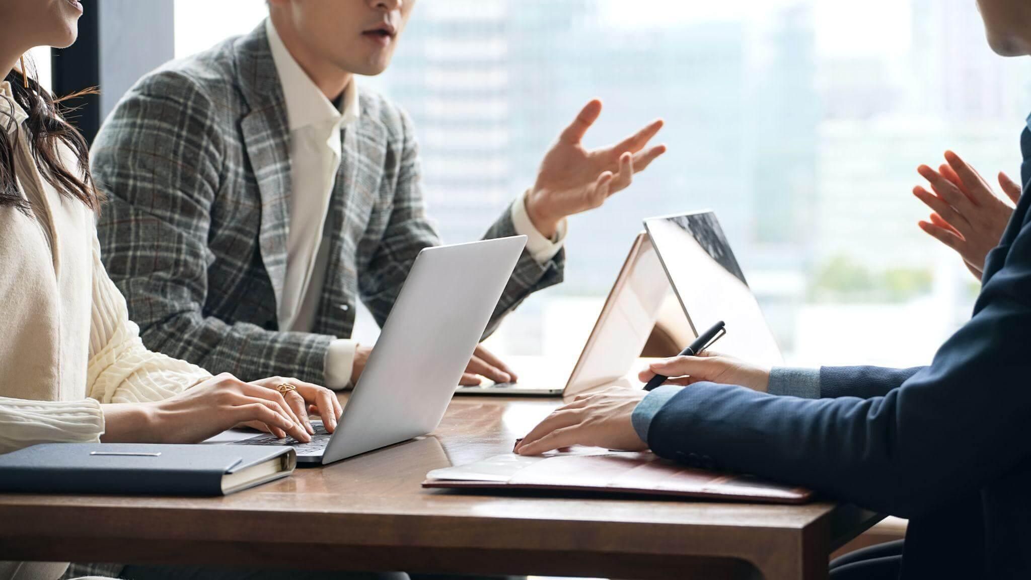 a group of people sitting around a wooden table