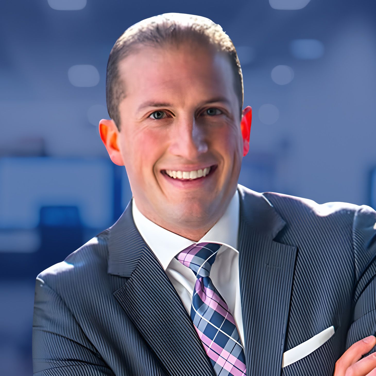 Business professional smiling in office setting, wearing suit and tie.