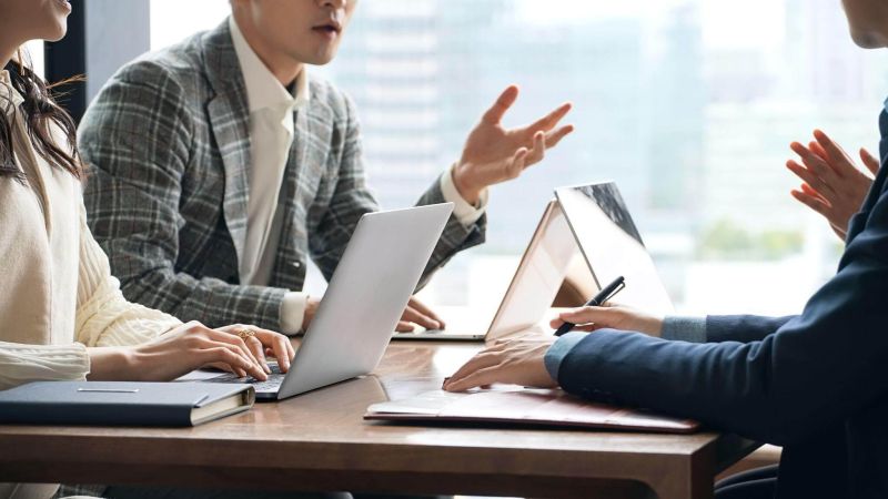 a group of people sitting around a wooden table