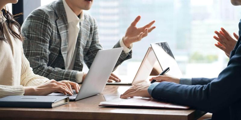 a group of people sitting around a wooden table