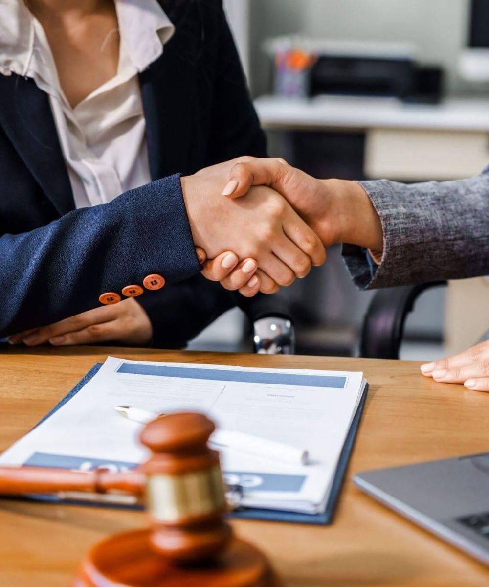 a couple of people shaking hands over a desk