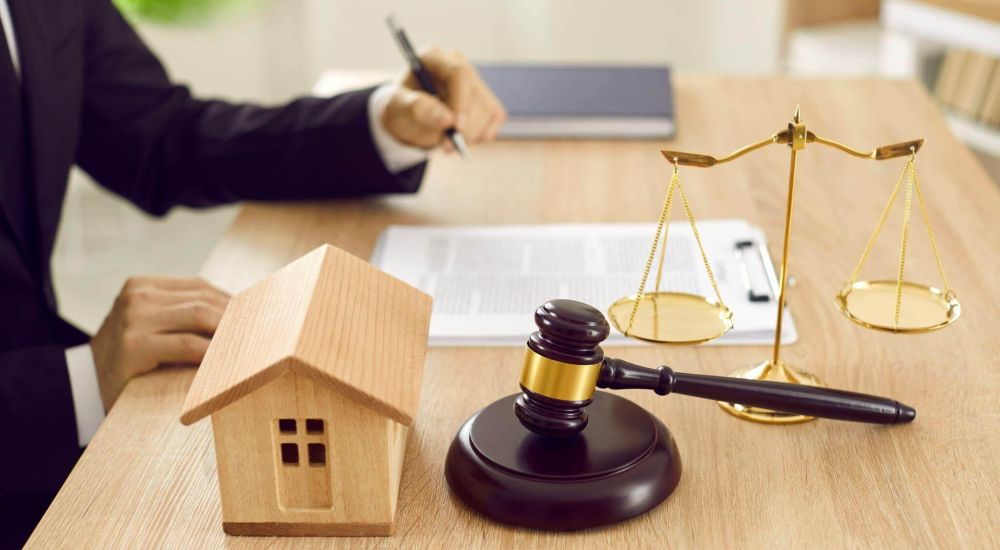 a judge's gavel and a model house on a desk