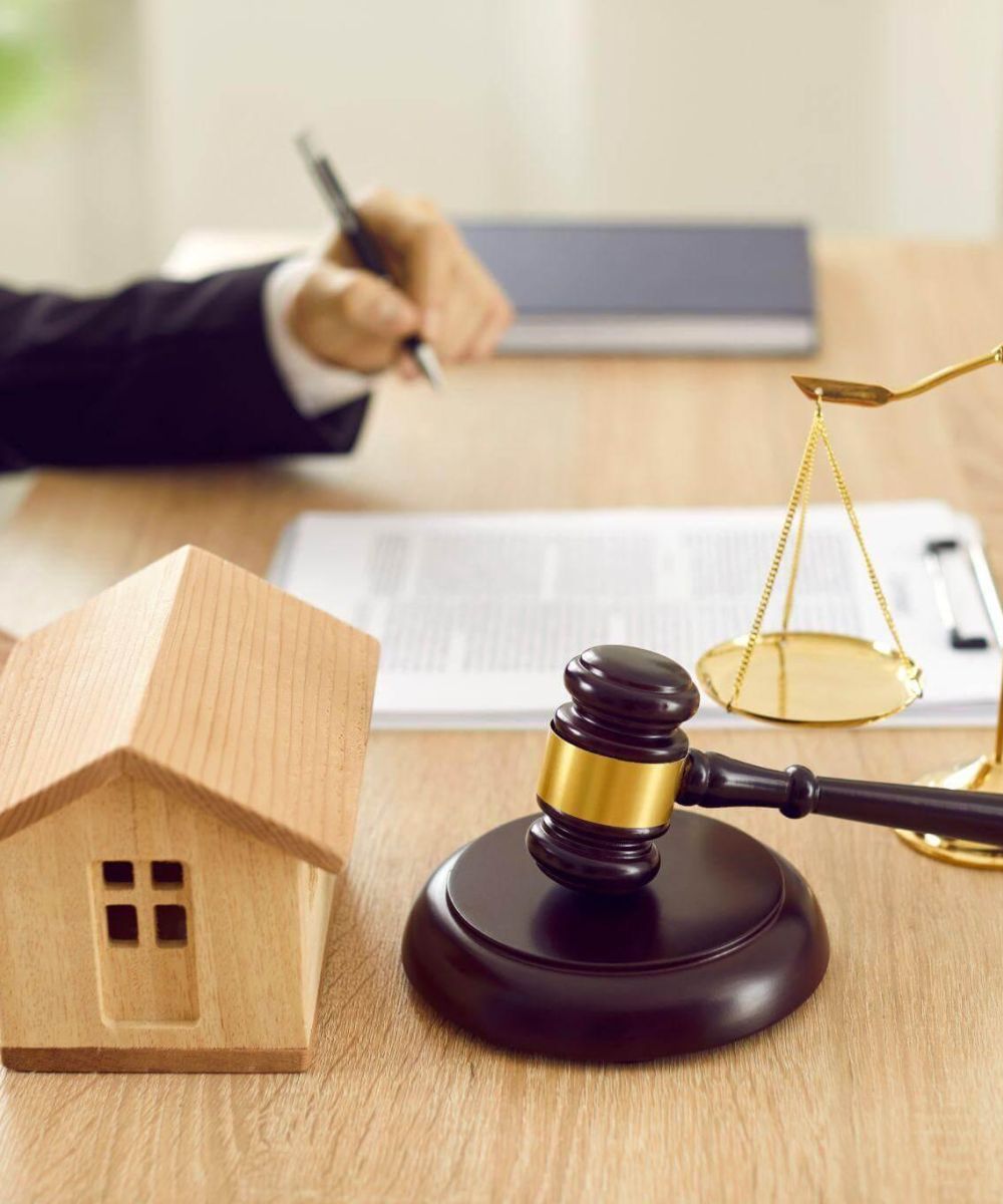 a judge's gavel and a model house on a desk