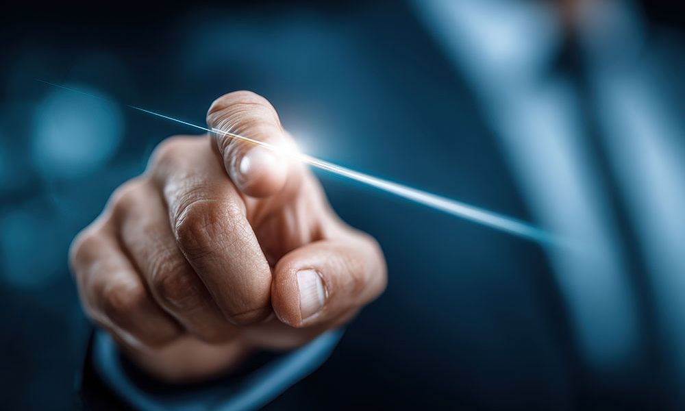 Finger touching digital interface with blue light, symbolizing technology and innovation in a futuristic business setting.