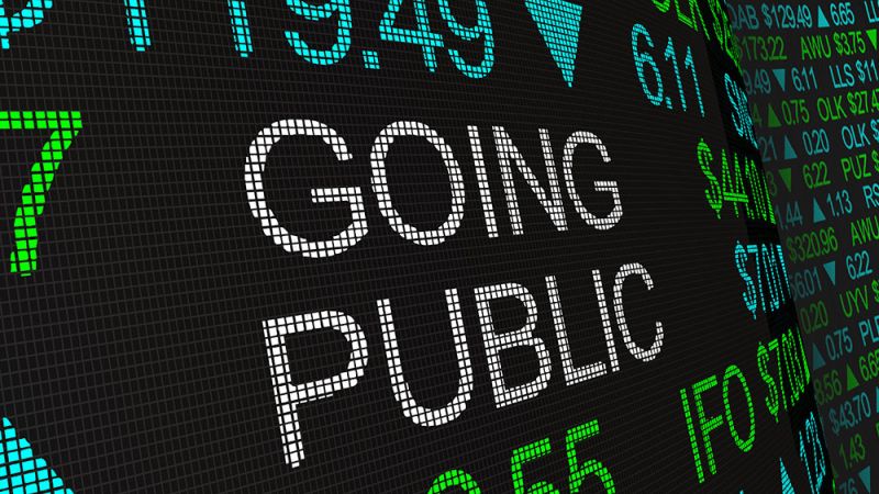 Stock market board displaying Going Public with fluctuating numbers and green and blue text indicating financial activity.