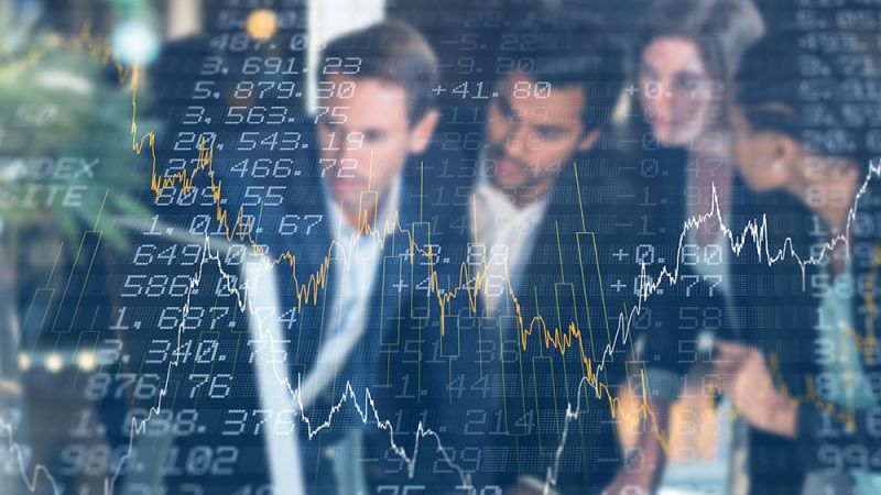 Business team analyzing financial data and stock market trends on a digital screen.