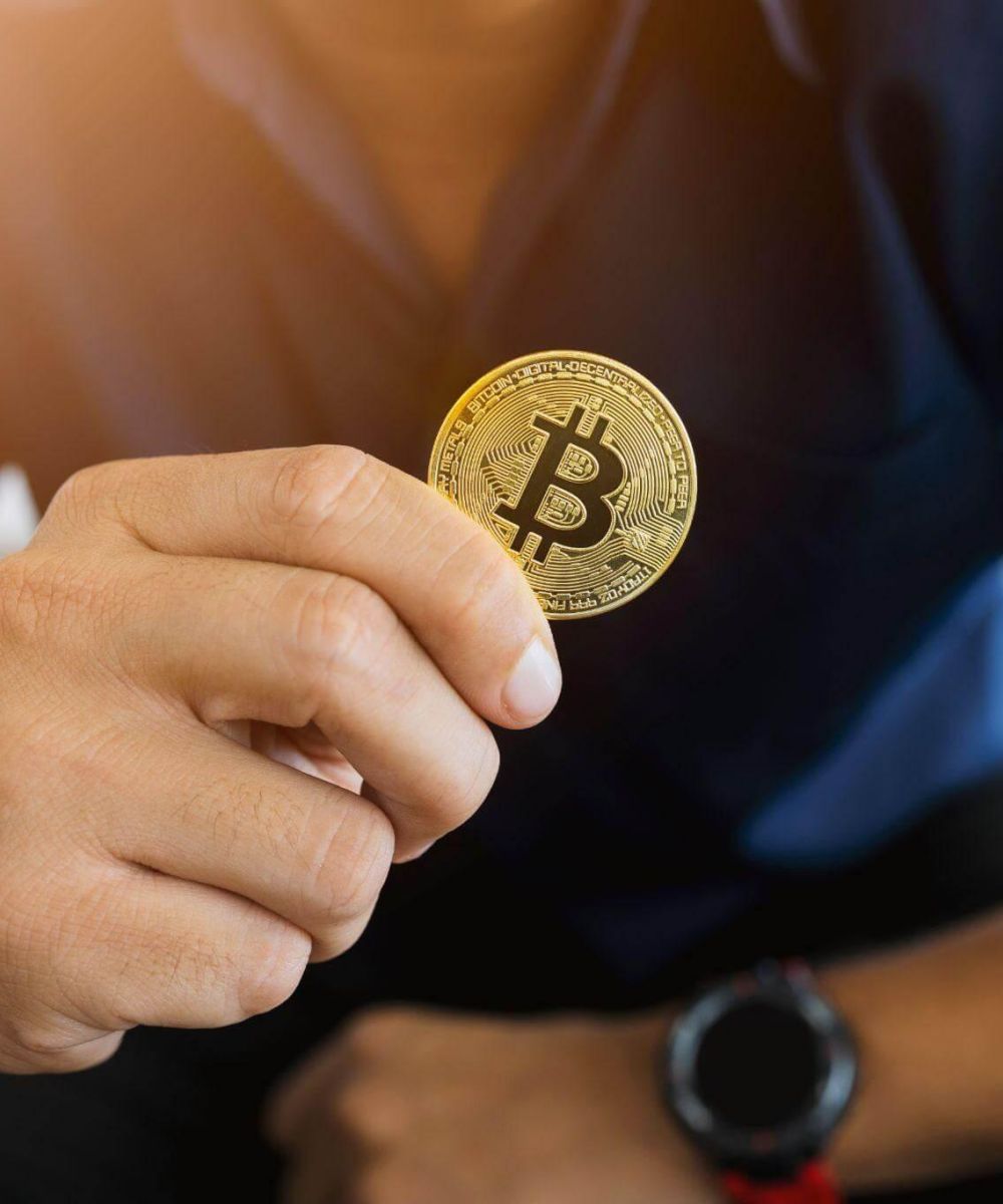 a man holding a bit coin in his hand