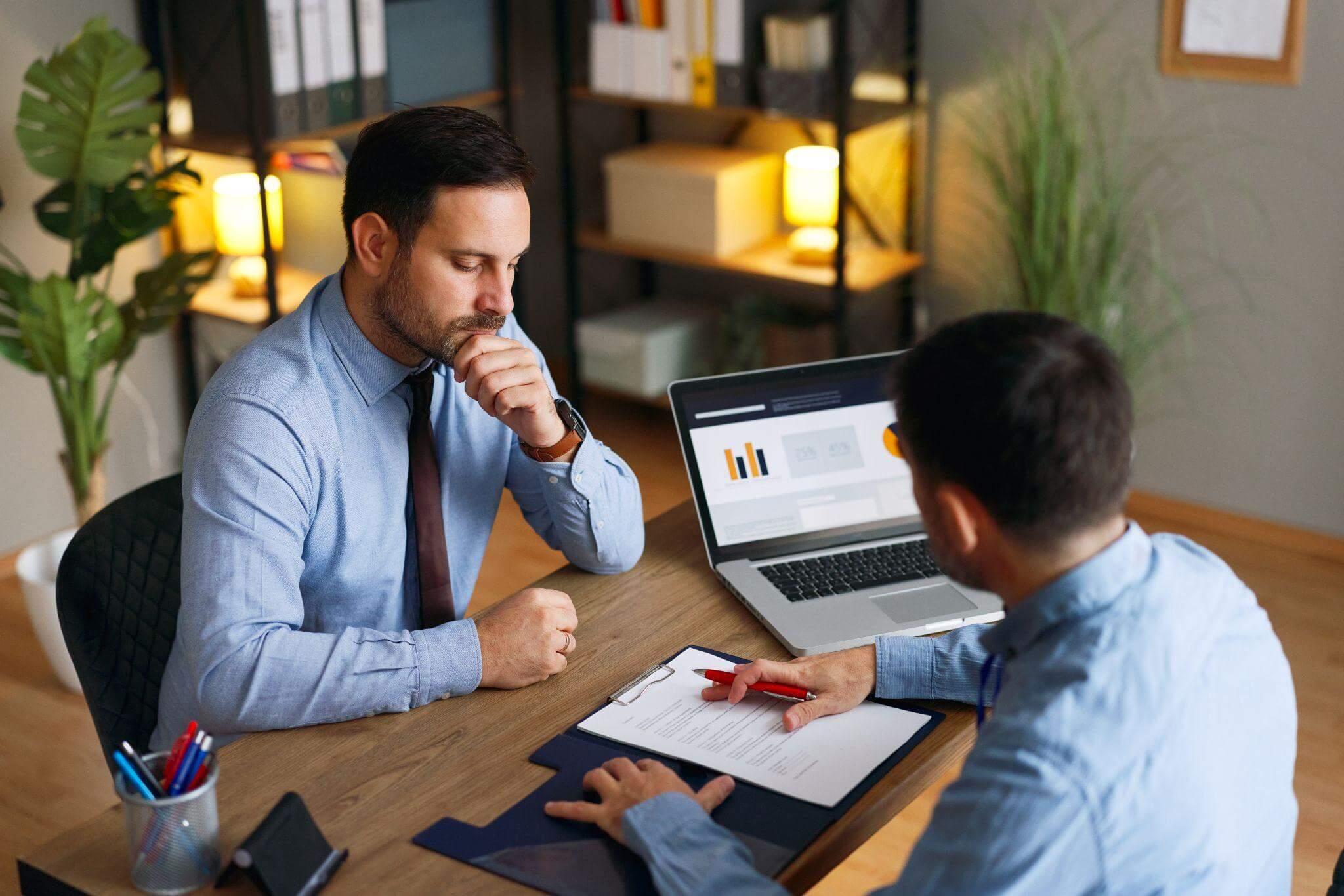 Man at desk reviewing papers, seeking legal guidance