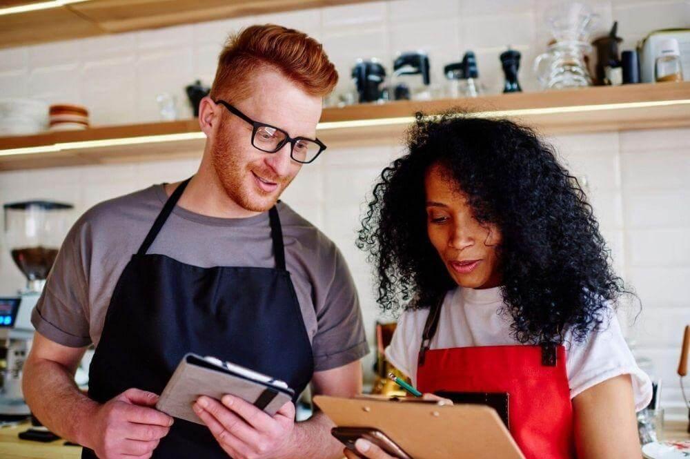 Man and woman in a restaurant kitchen reviewing franchise details